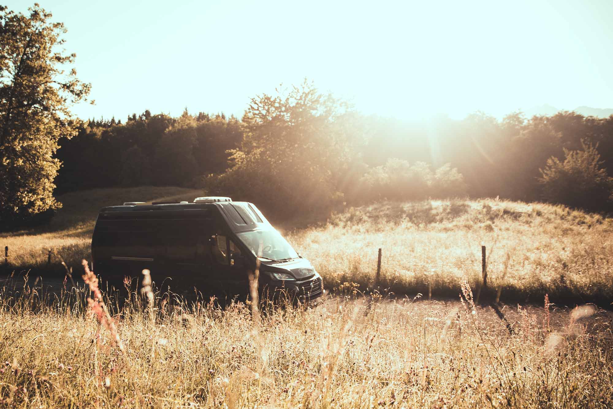 Campingbus fährt durch herbstliche Landschaft