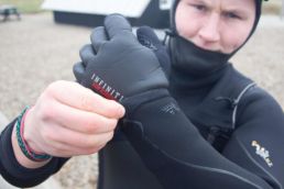 Ein Kiter zieht Handschuhe an